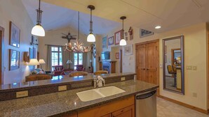 A spacious kitchen with granite countertops, wooden cabinets, and a built-in dishwasher. - Luxury 2-Bed Penthouse w/ Home Office (Crested Butte)