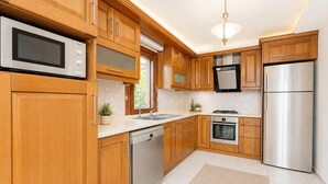 Una cucina moderna con mobili in legno, elettrodomestici in acciaio inossidabile e lavastoviglie integrata.