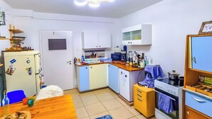 A compact kitchen with a dining area, a refrigerator, a stove, and a microwave. - Room 'Mondzimmer' with Wi-Fi (Kassel)