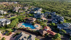 A residential area with a swimming pool, houses, and a mountainous backdrop. - New Listing 3 Bedroom on the Golf Course in sunny Poipu (Koloa)