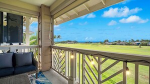 A balcony with a view of a golf course and ocean. - New Listing 3 Bedroom on the Golf Course in sunny Poipu (Koloa)