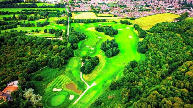 An aerial view of Ramsdale Park Golf Club with multiple green fairways, sand bunkers, and a residential area in the background. - Spacious & Luxury 2BR Flat in Calverton (Calverton)