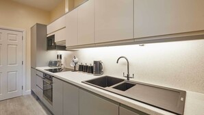 Cozinha moderna com eletrodomésticos de aço inoxidável, uma pia dupla e um micro-ondas.