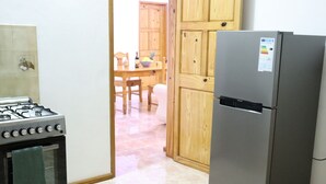 A kitchen with a gas stove, oven, and a refrigerator. - Sunset view suite personal Patio wiew panoramic mountain view and sunset (Trou D'eau Douce)