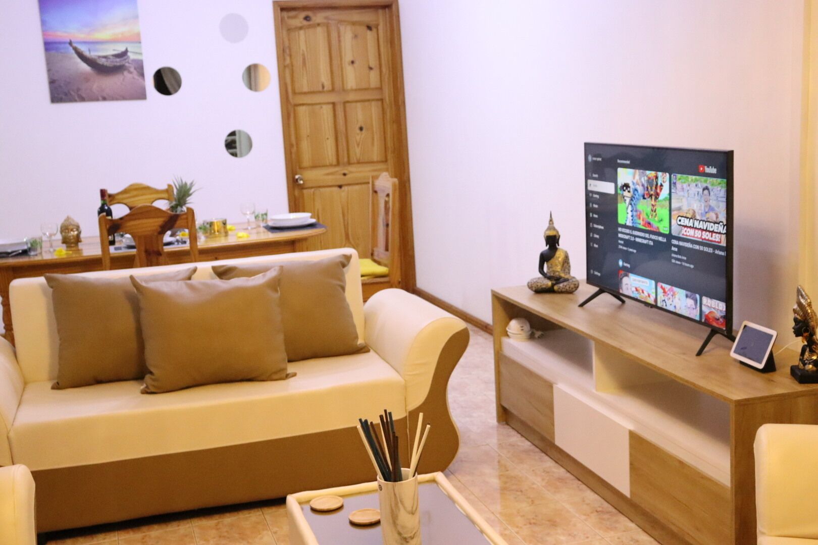 A living room with a sofa, a coffee table, a TV, and a wooden door.