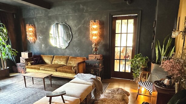 A cozy living room with a sofa, bench, and a fur rug. There are two wall sconces and a large mirror. - Designer Corner Unit Suite, Cozy 1-bedroom apt, Laundry, AC, (New York)