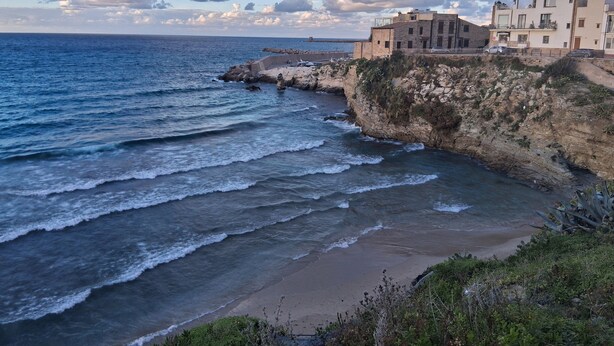 Un edificio frente al mar, con vistas a las acantilados.