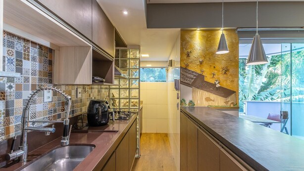 Uma cozinha moderna com cafeteira, pia de aço inoxidável e painel decorativo.