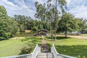 A gazebo by a lake with a stone pathway leading to it, surrounded by lush greenery and trees. - The Place to Be – Sleeps 16, Kayaks, Hot Tub, Games, Fire Pit + More! (Eatonton)