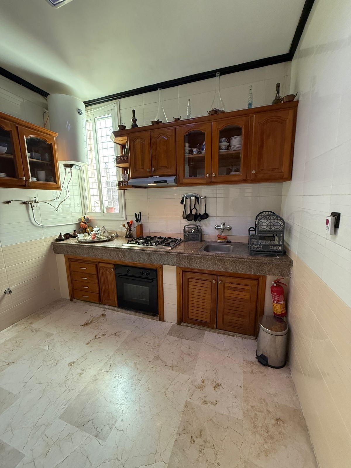 A kitchen with wooden cabinets, a gas stove, and a sink.