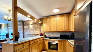 Una cucina moderna con mobili in legno, forno integrato e frigorifero in acciaio inossidabile.