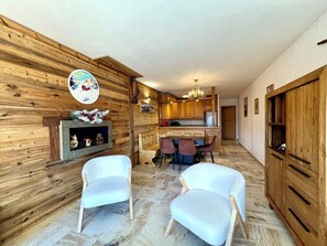 A wooden interior with a fireplace, a dining area, and a kitchen. - The Balcony of the Giant in Combloux (Combloux)