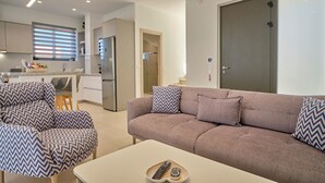 Una sala moderna con sofá, sillones y una mesita de centro.