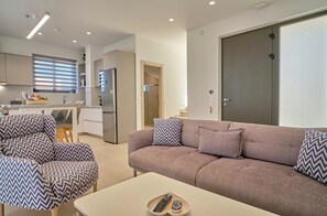 A modern living room with a sofa, armchairs, and a coffee table. - Arillas Villas Dinos (Corfu)