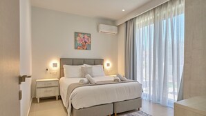 Un dormitorio moderno con una cama grande, mesitas de noche, un cuadro y una ventana con cortinas.
