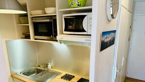 A compact kitchen with a sink, stove, microwave, and a small refrigerator. - Bright apartment with views of Mont Blanc (Chamonix-Mont-Blanc)