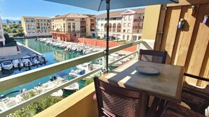 Un balcó amb vista a un port esportiu i edificis.