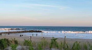 A beach with waves, people, and a clear sky. - Charming Coastal Retreat 1BR (Rockaway Beach)