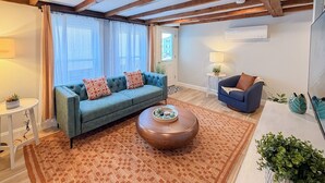 Ein Wohnzimmer mit einem blauen Sofa, einem runden Couchtisch und einem blauen Sessel.