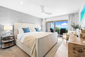 A modern hotel room with a large bed, a desk, a chair, a small table, and a view of the ocean. - Tivoli by the Sea (Siesta Key)