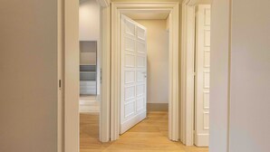 Un couloir avec des portes blanches et un plancher en bois.