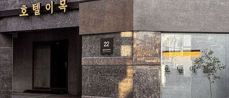 A building entrance with a sign reading "Hotel Name" and a number "22" indicating the room number.