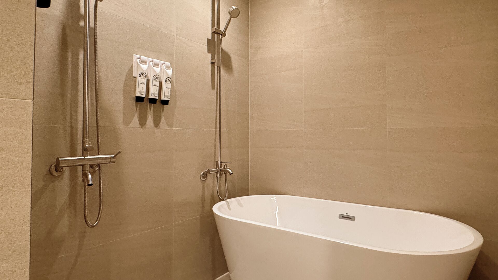Une salle de bain moderne avec une baignoire sur pieds, une douche avec un pommeau de douche amovible et un porte-serviettes avec trois serviettes.