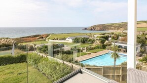 En boligejendom med swimmingpool, havudsigt og have.