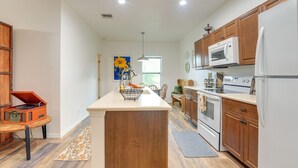 A modern kitchen with wooden cabinets, a central island, and a built-in oven. - Private Lake Access, Enjoy Serenity @ Bunk South (Palm City)