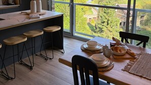 A modern kitchen with a large window overlooking a scenic landscape.