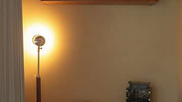 A room with a wooden desk, a lamp, a chair, and a small decorative chest.