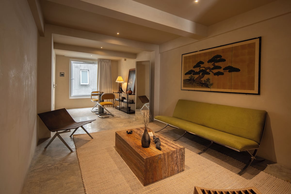 Un salon moderne avec un canapé, une table basse et un tableau accroché au mur.