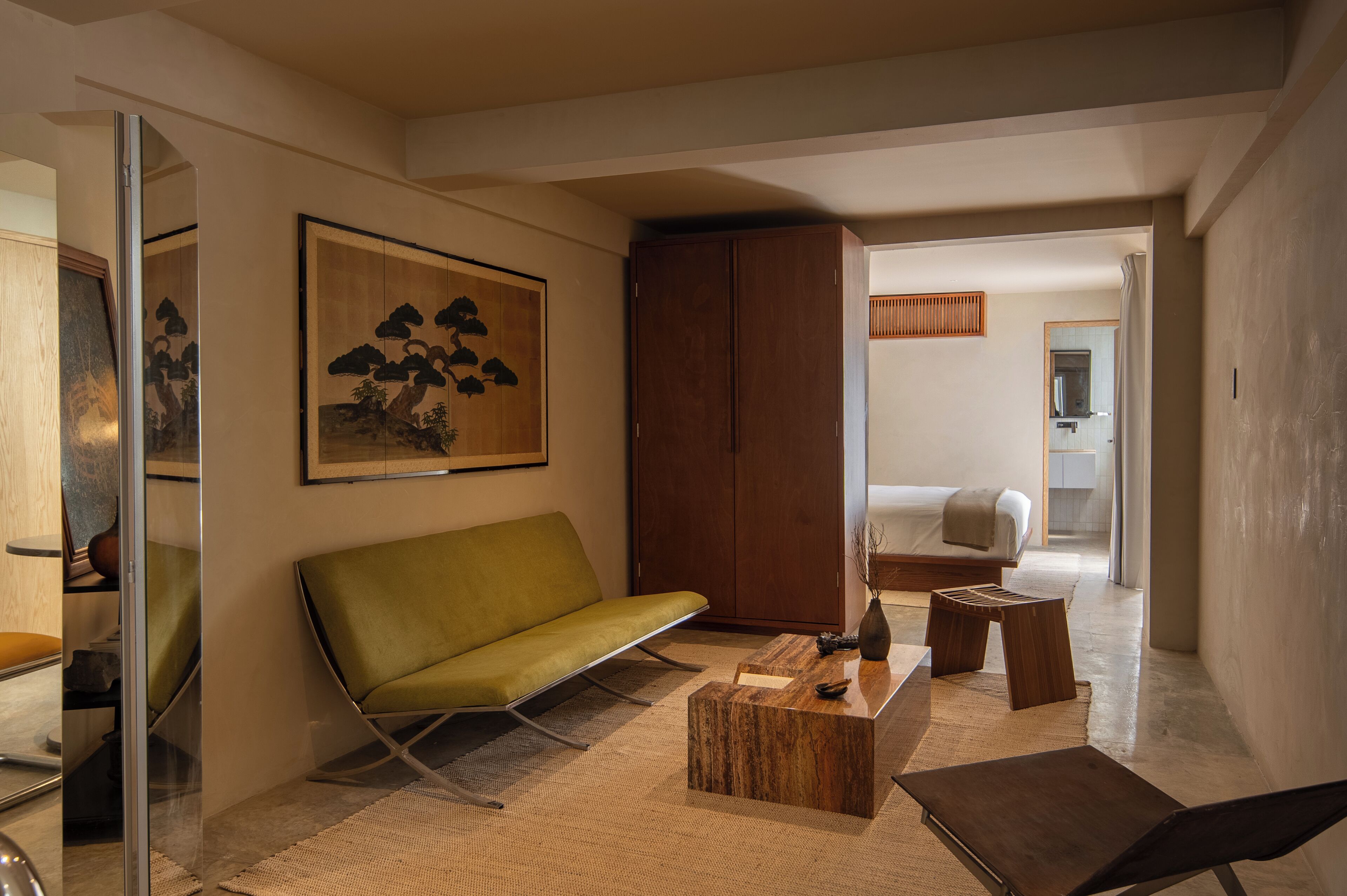 Un salon moderne avec un canapé vert, une table basse en bois et un tableau accroché au mur.