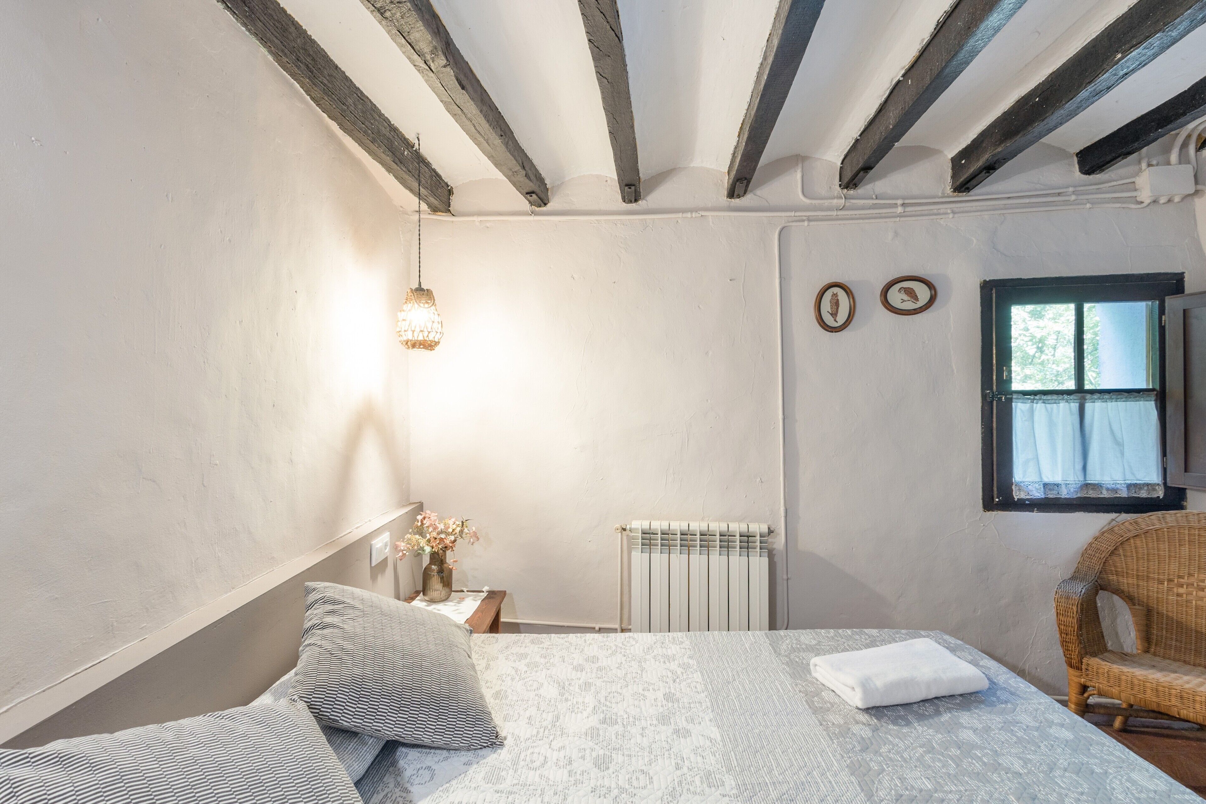 Une chambre à coucher avec un lit, une chaise, un radiateur et une fenêtre.