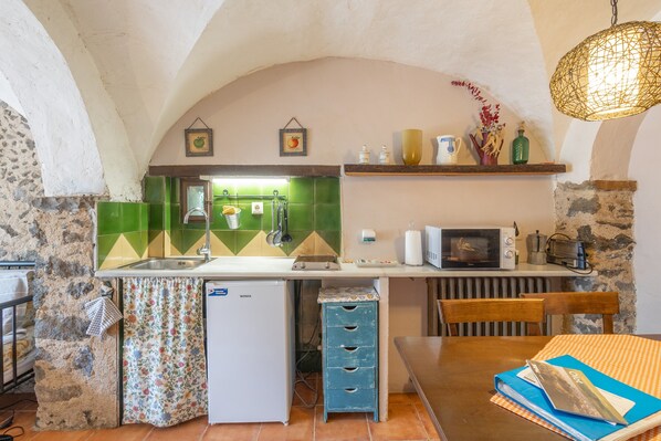 A compact kitchen with a sink, a microwave, and a small refrigerator.