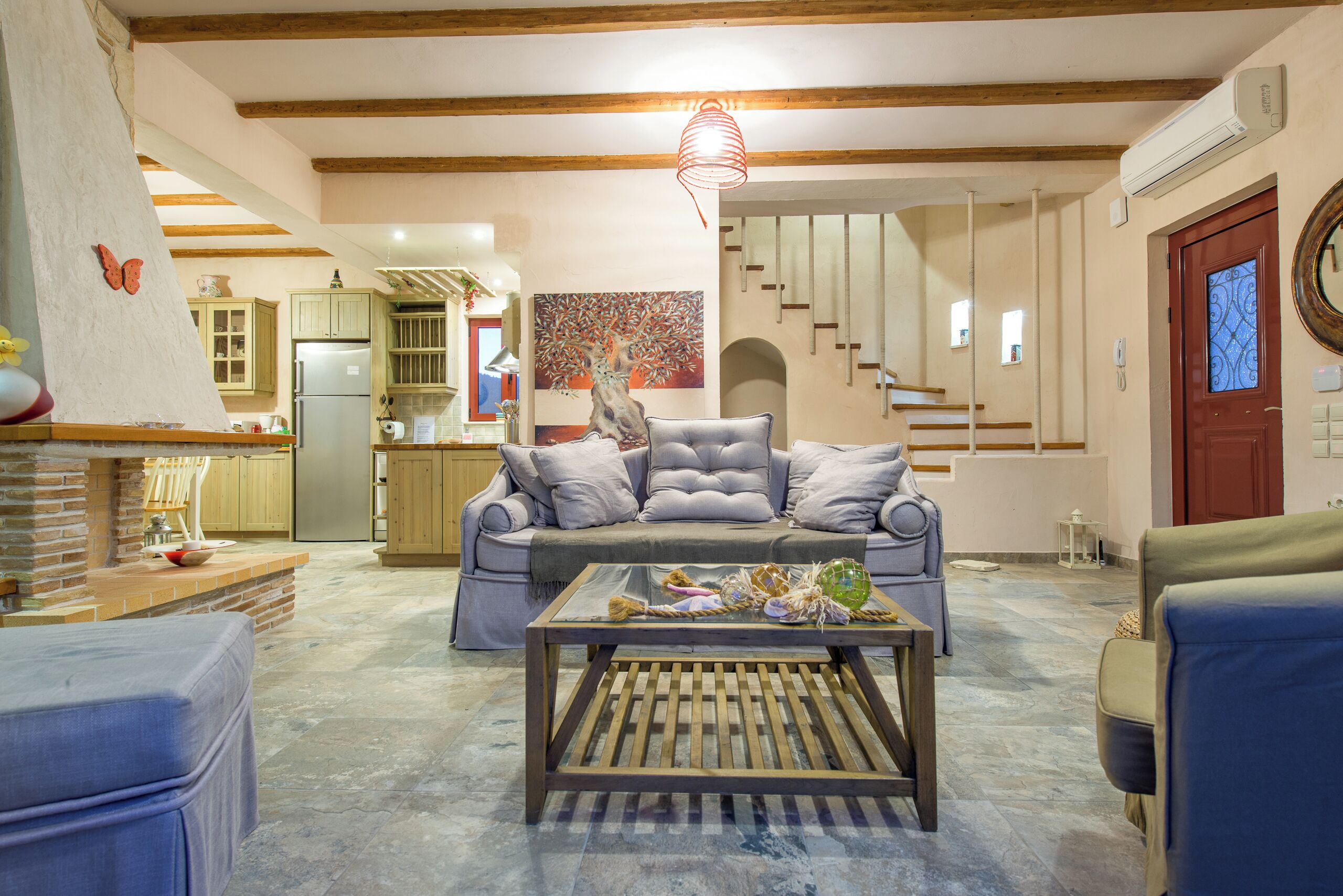 Una sala de estar con un sofá, una mesa de centro y una cocina al fondo.