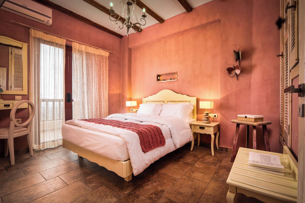 A bedroom with a bed, bedside tables, a desk, and a chair.
