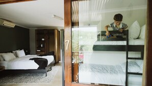 A bedroom with a bunk bed, a wooden wardrobe, and a large window. - Matatane Wilderness Camp (Babanango Game Reserve)