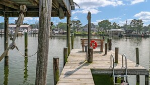 A wooden dock extending into calm water with a lifebuoy and a bench. - Tilghman | Pool | Private Dock | Pet Friendly (Tilghman)