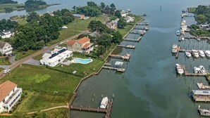 A marina with docked boats, a swimming pool, and residential buildings. - Tilghman | Pool | Private Dock | Pet Friendly (Tilghman)