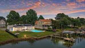 A lakeside property with a swimming pool, dock, and houses. - Tilghman | Pool | Private Dock | Pet Friendly (Tilghman)