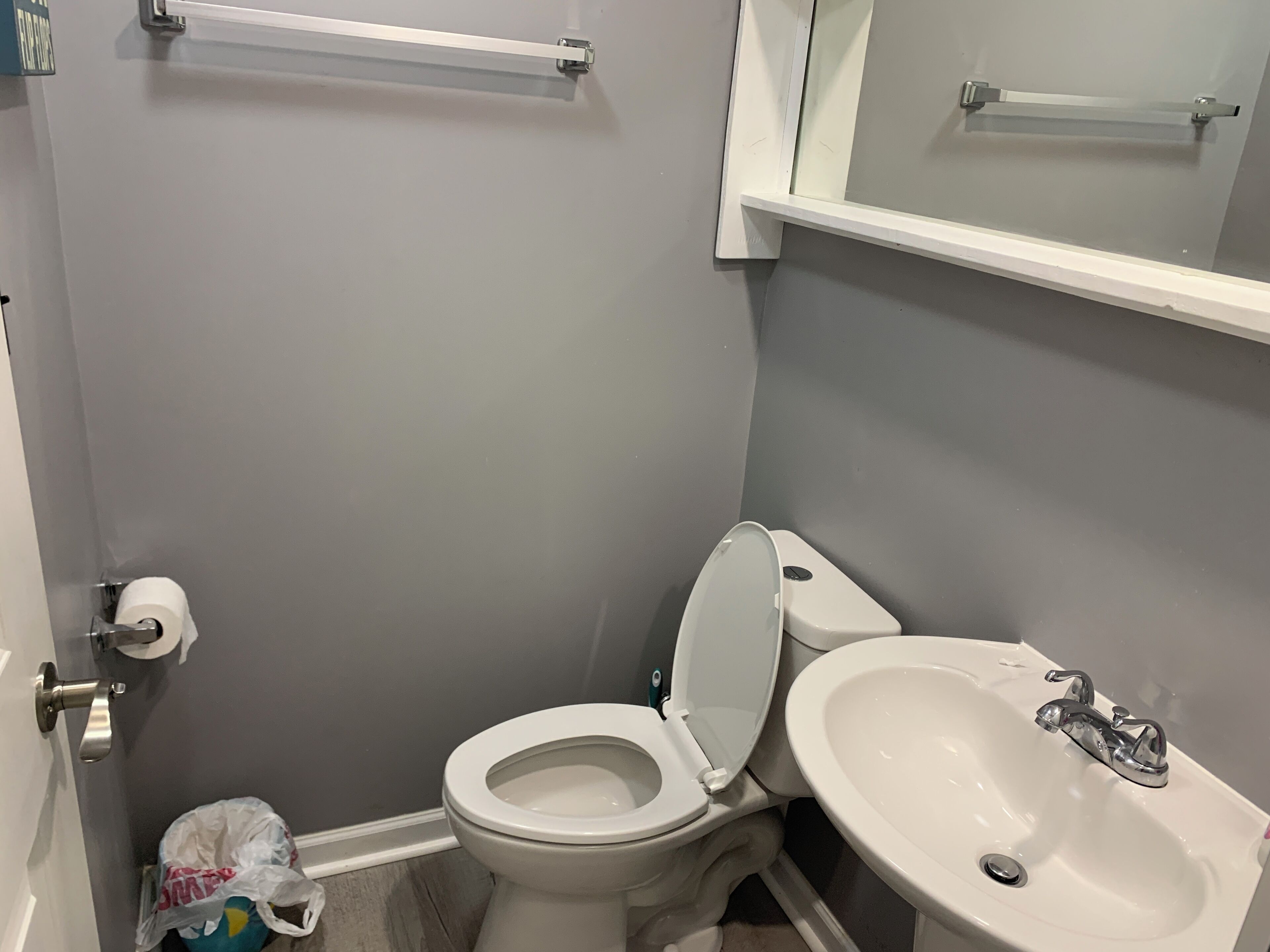 Un baño pequeño con inodoro, lavamanos y espejo sobre el lavamanos.