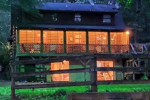 A wooden cabin with multiple windows and a balcony, surrounded by greenery. - Private Dock & Game Room! Lake Hartwell Retreat (Townville)
