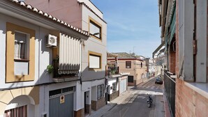 A narrow street with buildings, a scooter parked on the side, and a clear sky. - Apartment 'Casacuéntame' with Private Terrace, Wi-Fi and Air Conditioning (Granada)