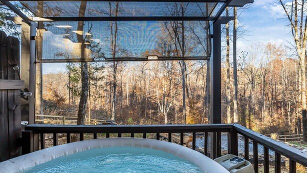 Un jacuzzi en una terraza con vistas a un bosque.
