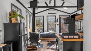 Una cocina moderna con una estufa grande, un refrigerador y un comedor con mesa de madera.