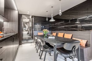 A modern kitchen with a dark marble backsplash, stainless steel appliances, and a central island with seating. - LUXURIOUS PARISIAN DUPLEX WITH SEINE VIEWS IN HISTORIC ÎLE SAINT-LOUIS - 3 BEDS (Paris)