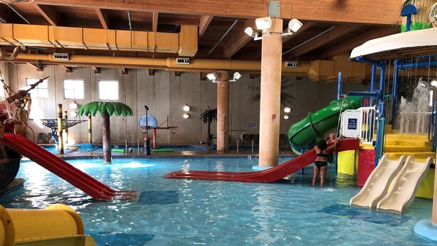Ein großer Wasserpark mit Rutschen, einem Schwimmbecken und einem Spielbereich.