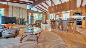 A spacious living room with a large TV, leather sofa, and a wooden coffee table.