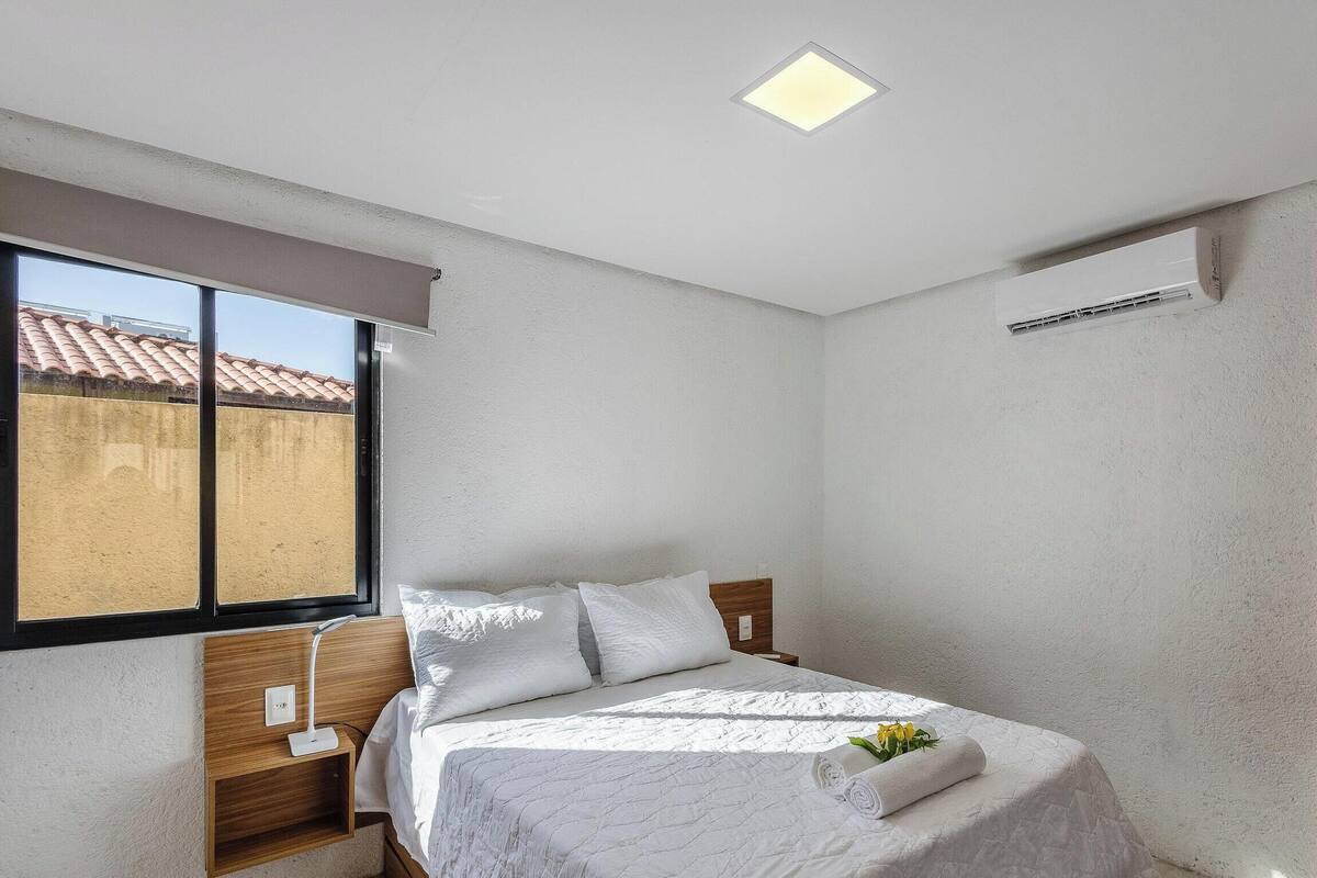Una camera da letto con un letto, una finestra e una lampada a sospensione.